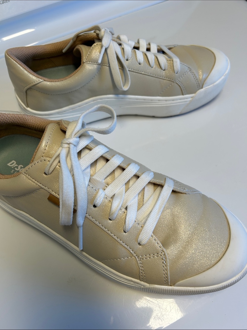 Glistening cream sneaker with white sole and laces
